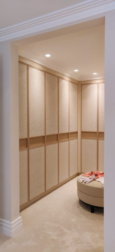 Sand Beige dressing room. Doors with integrated finger pull. Modern interior corner with light wood cabinetry and soft lighting.
