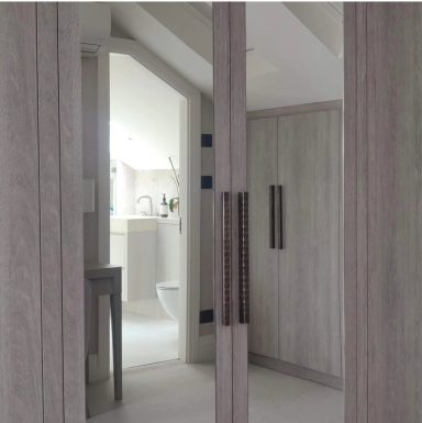 Mirrored Wardrobe Doors A modern bathroom with wooden cabinetry and visible fixtures in soft lighting.